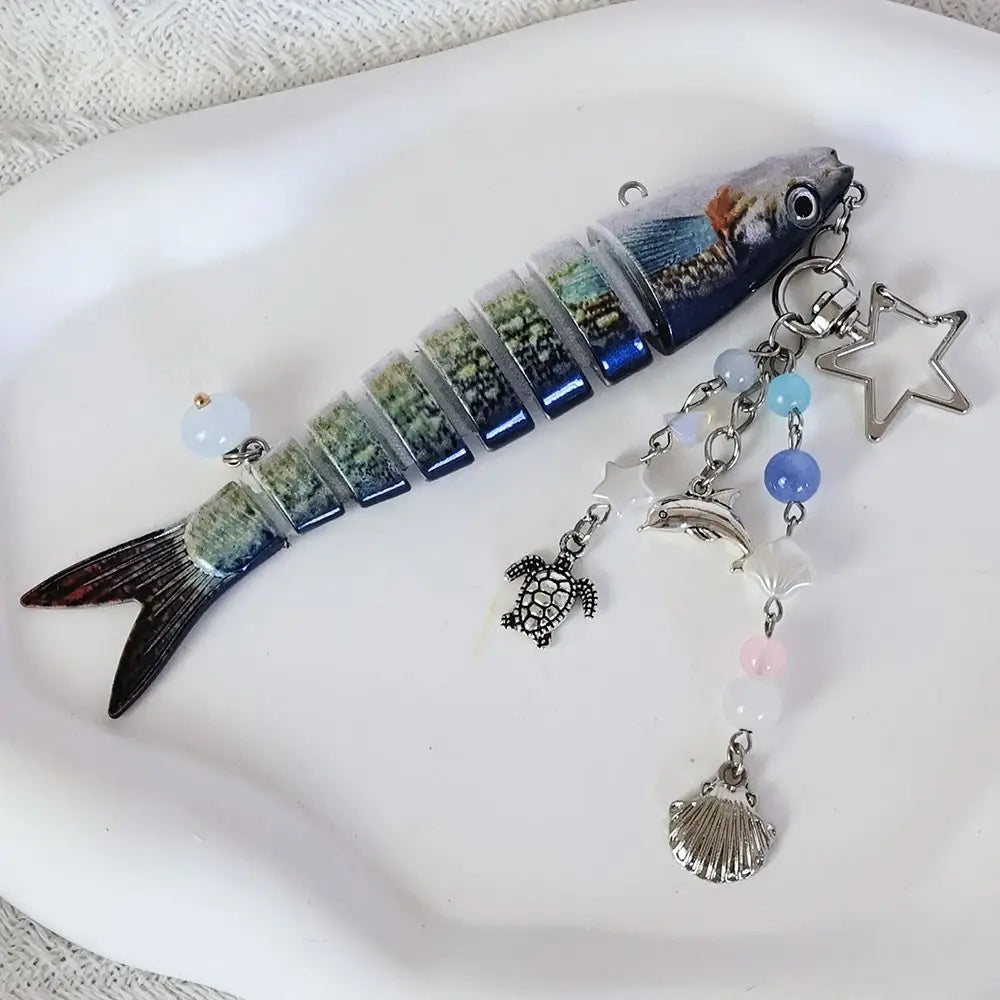 A realistic simulation fish keychain featuring iridescent blue and green scales, attached to a silver charm.