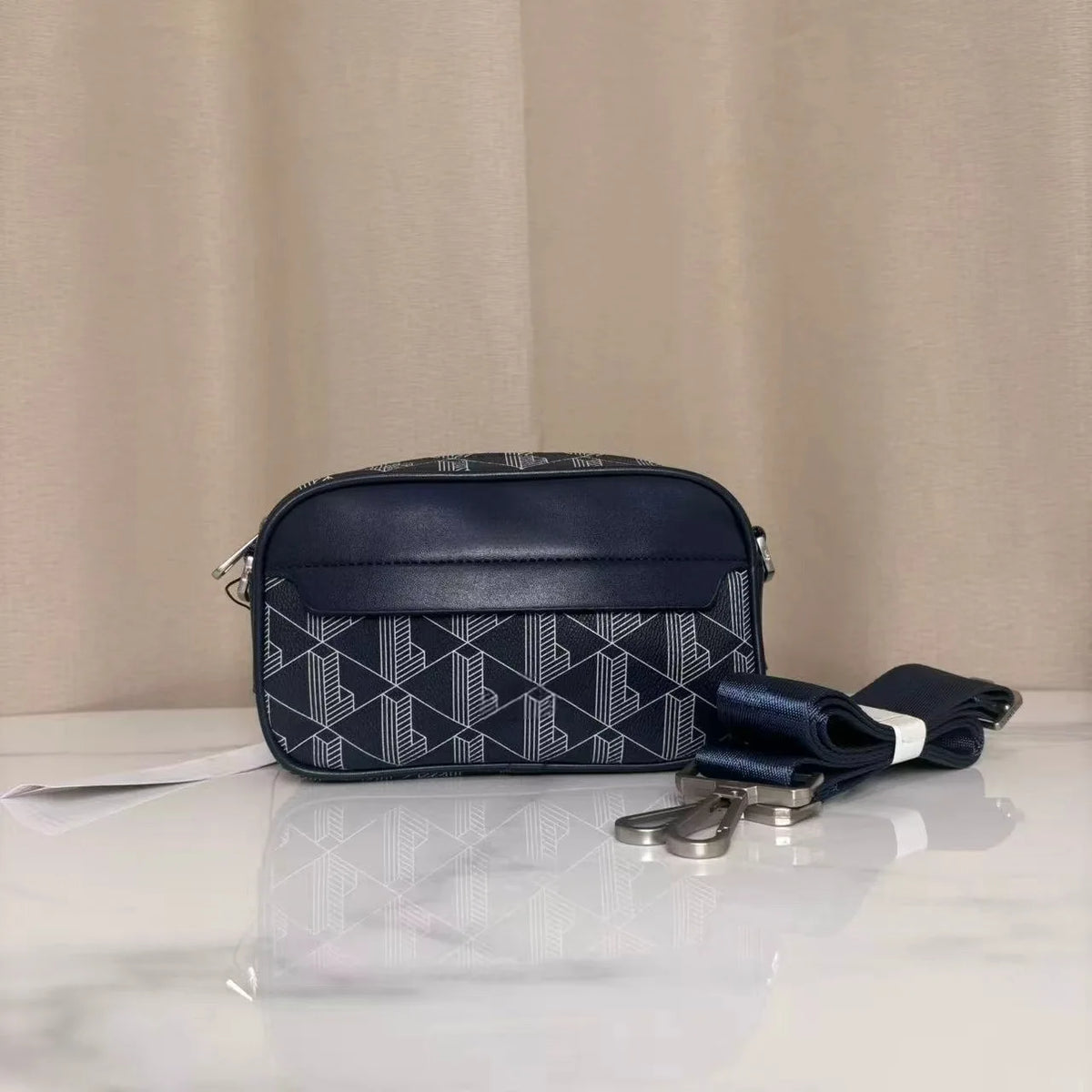 Dunkelblaue PU-Leder-Herren-Crossbody-Tasche mit geometrischem Muster auf weißem Marmor.
