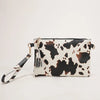 A white and black leopard print faux leather wrist bag with gold hardware.
