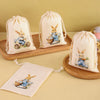 A set of six light beige drawstring gift bags featuring illustrations of an Easter bunny on them.