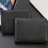 Black textured slim wallet or card holder with stitching and an orange accent on a dark surface.