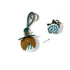 A green leather keychain with a floral charm featuring blue and white textured fabric.