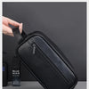 A black textured leather cosmetic bag is shown next to a razor and a blue man skin product.