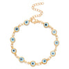 A gold charm bracelet featuring blue evil eye charms on an adjustable chain.