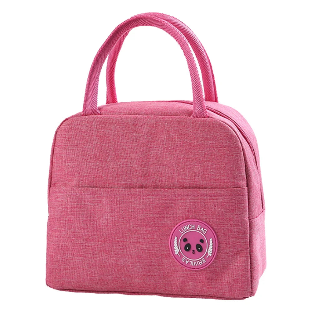 A pink insulated canvas lunch bag with a gold letter print on the lid.