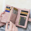 A hand is opening a pink multi-slot frosted card wallet displaying various credit cards and an ID.