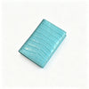 A teal genuine leather passport holder with a crocodile pattern and custom initials, shown at an angle.