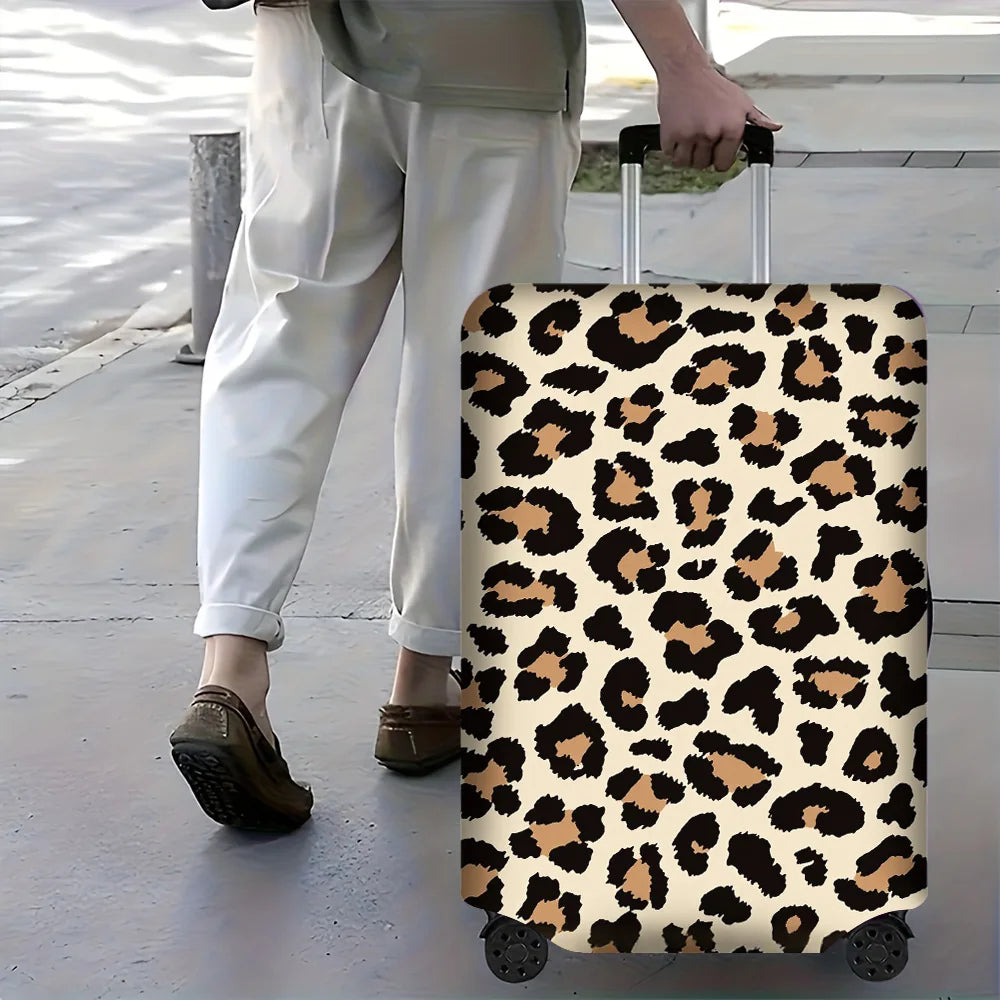 A leopard print protective luggage cover on a rolling suitcase being pulled by a person.