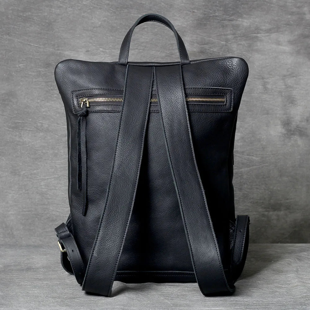 A black genuine full-grain leather backpack shown from the back.