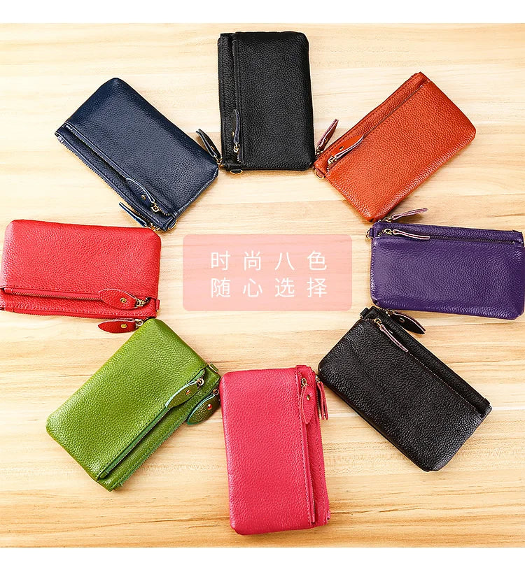 Eight genuine leather wristlet clutch wallets in various colors arranged in a circle on a wooden surface.