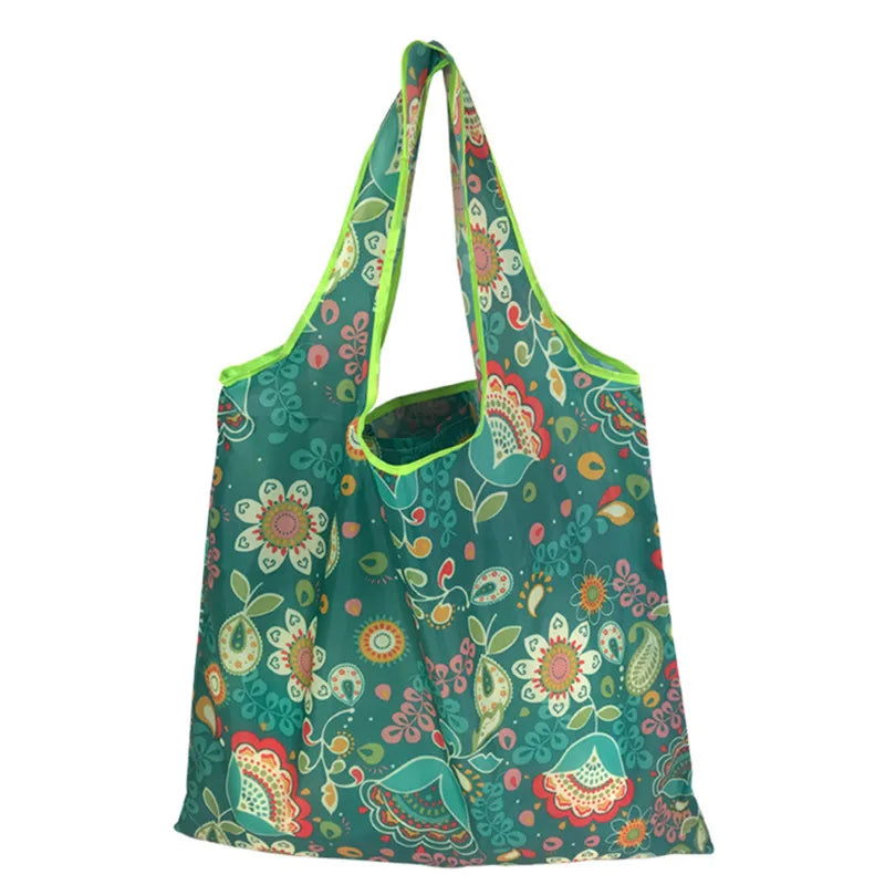 A reusable tote bag made of green nylon fabric with a floral pattern.