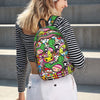 A woman is wearing a colorful, patterned sport backpack while standing outdoors.