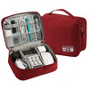 A red leather cable storage organizer bag with an open compartment showing various electronic cables and accessories.