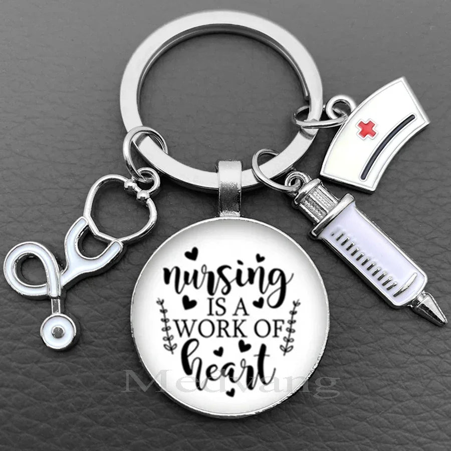 Silver keychain featuring a stethoscope charm and a circular pendant with the text Nursing is a work of heart