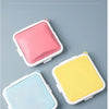 Three silicone reusable sandwich boxes in pink, yellow, and light blue displayed on a gray background.