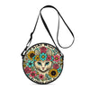 A round crossbody bag featuring a colorful floral design with a cat face and black strap.