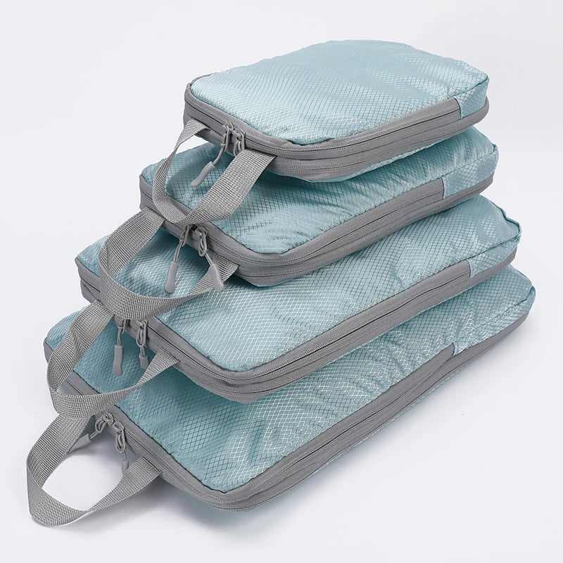 A stack of four light blue fabric travel organizer bags with gray straps.