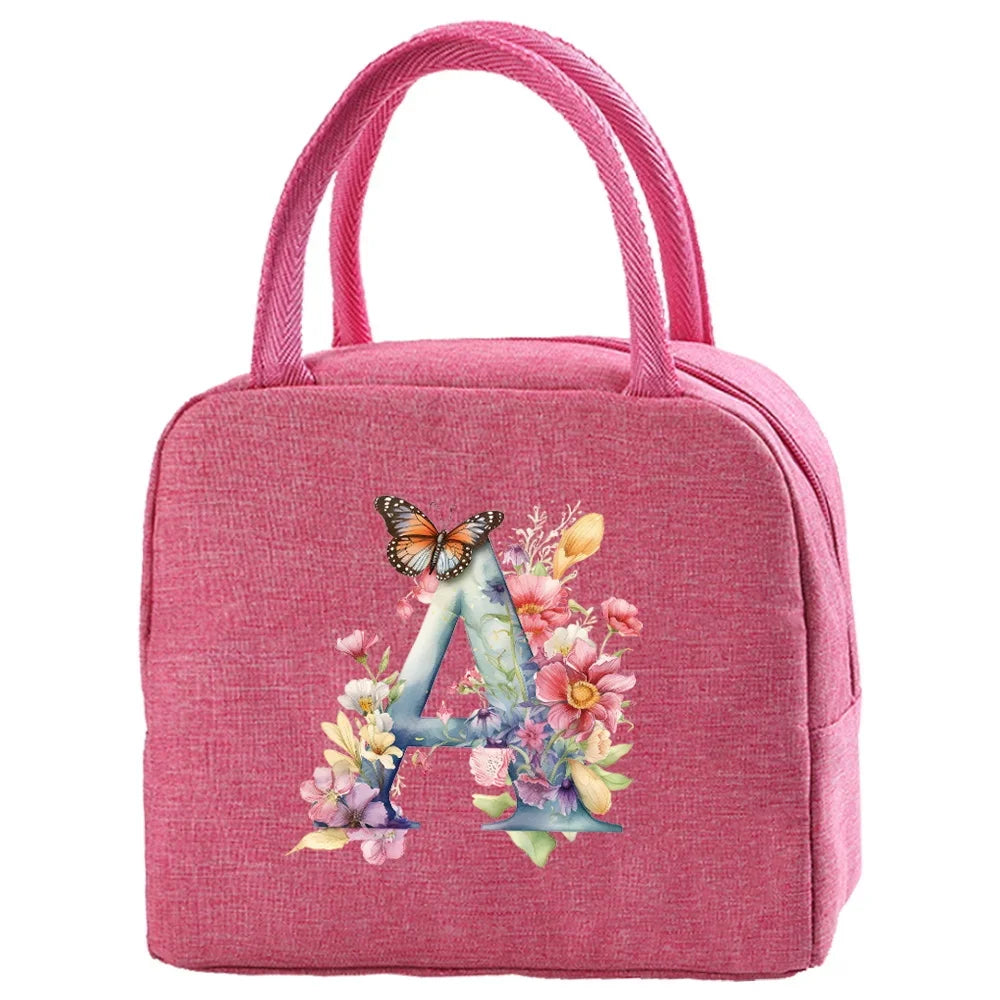 A pink insulated canvas lunch bag featuring a large blue letter A decorated with floral elements.
