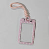 A pink polka dot card holder with a lanyard is shown against a white background.