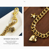Gold alloy bag pendant necklace featuring a delicate chain and a flower charm.