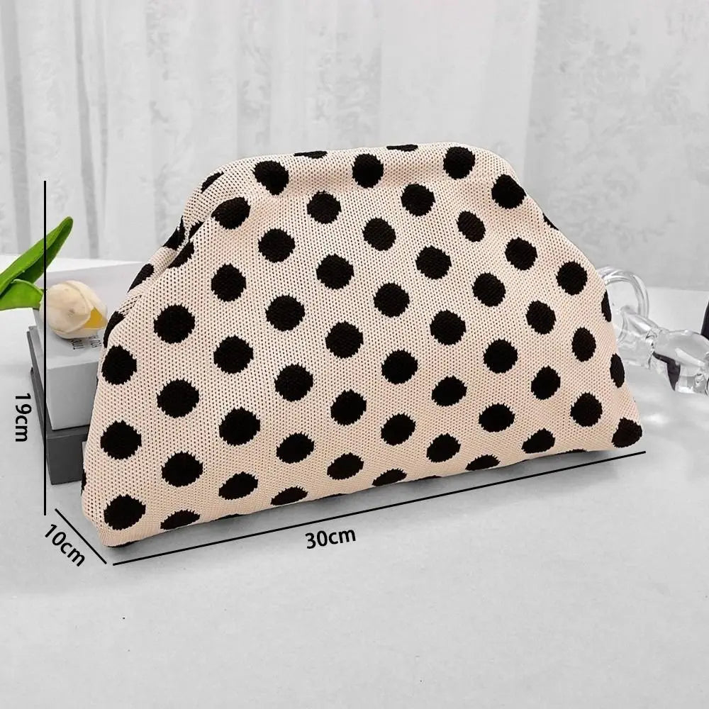 A beige polka dot clutch bag is displayed on a white surface with size measurements.
