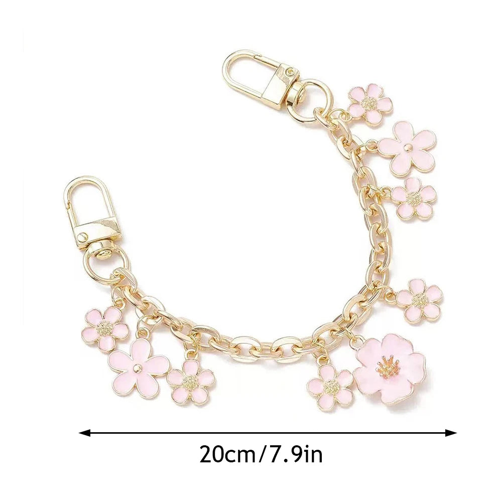 Accesorio de bolso con cadena tono dorado, charmes de corazón y flor de cerezo en esmalte