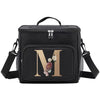 Black insulated canvas lunch bag with dual handles featuring a gold initial M and floral accents.