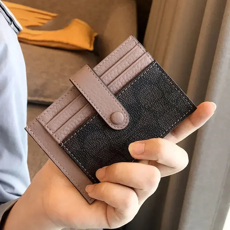 Une main tient un porte-cartes portefeuille en cuir PU marron et noir pour la carte d'identité et les pièces.
