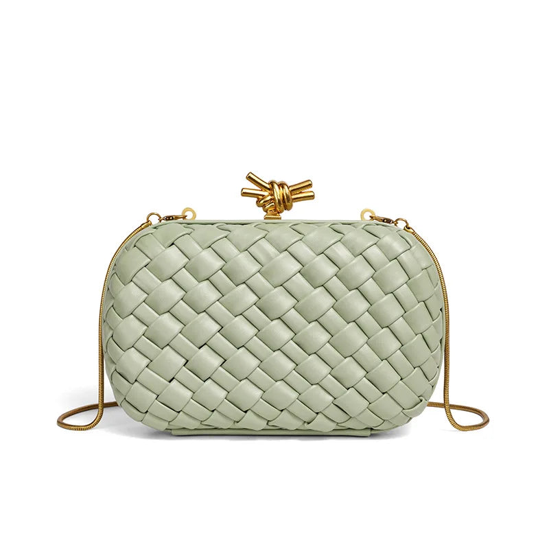 A light sage green handwoven clutch evening bag with a gold-toned clasp and thin gold chain strap.