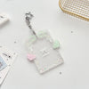 Clear acrylic photocard holder with a silver charm and pink and green decorative elements