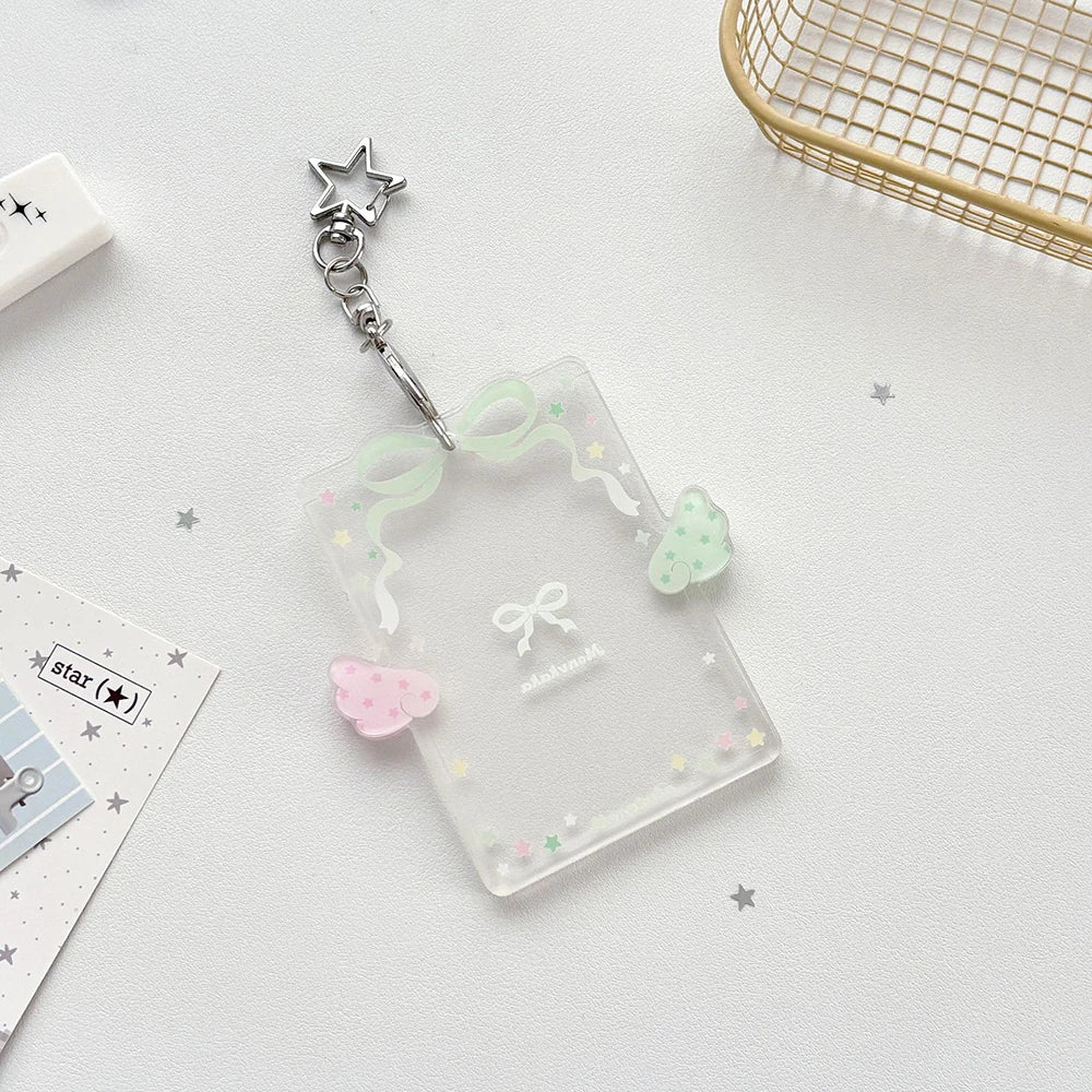 Clear acrylic photocard holder with a silver charm and pink and green decorative elements