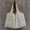 A light yellow reusable shopping bag patterned with small pastel-colored illustrations of animals and food items.