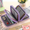 Purple pencil case with dividers and multiple pens and pencils displayed on a wooden surface.