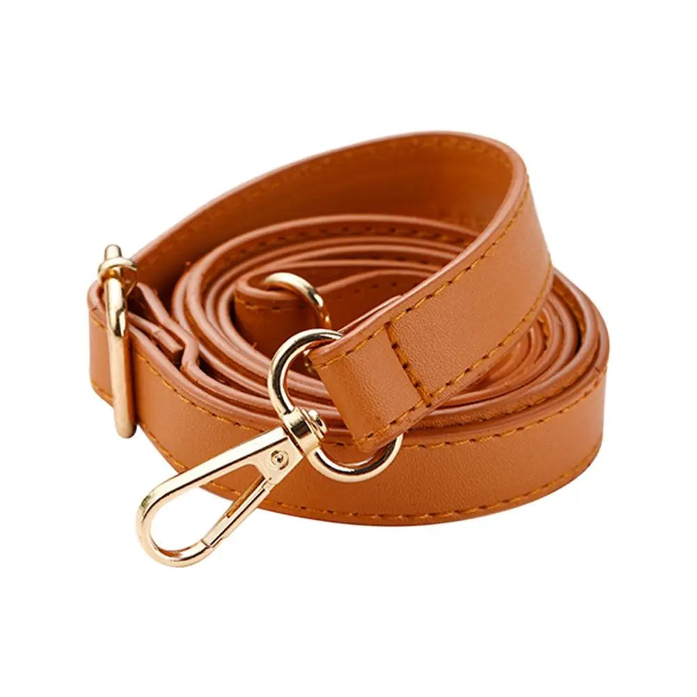 Une lanière en cuir fauve enroulée avec une boucle dorée sur fond blanc.