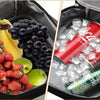 Isoliertem Lunchbeutel gefüllt mit frischem Obst wie Trauben, Erdbeeren und Äpfeln sowie Eis und einer Limonade.