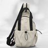 A beige casual backpack with black straps and a laptop compartment shown from the back.