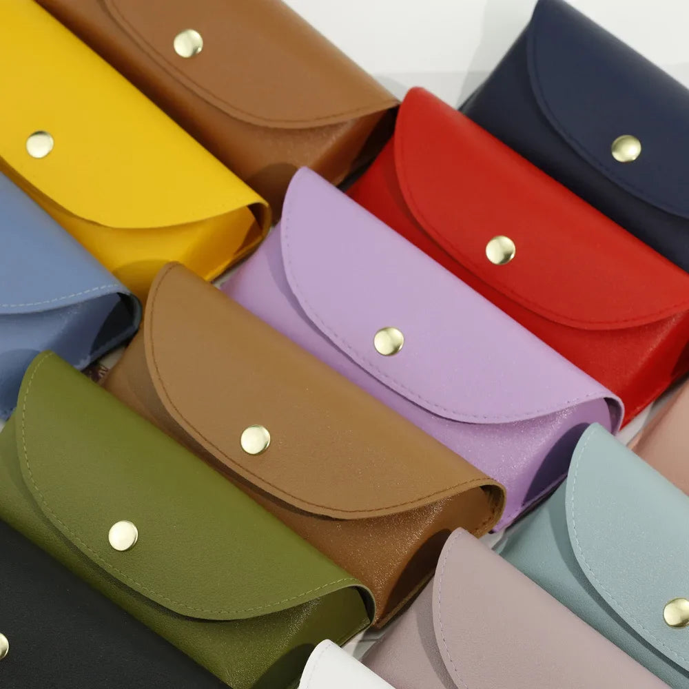 A collection of PU leather hard shell sunglasses cases in various colors including yellow, brown, red, purple, and blue.