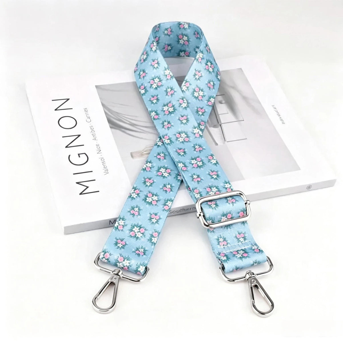 Light blue floral patterned nylon crossbody bag strap with a silver metal buckle