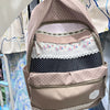 A light pink backpack with floral and polka dot patterns is displayed on a hanger.