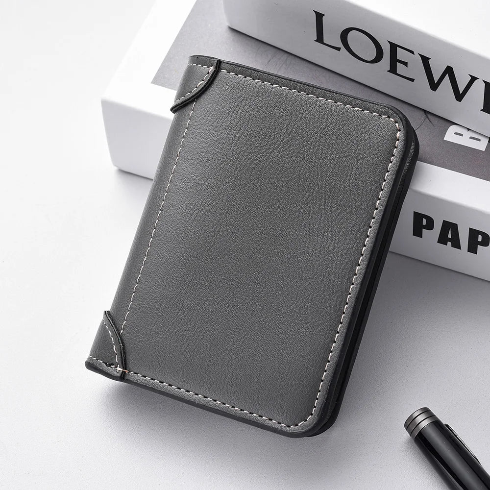 A dark gray ultra-thin PU leather credit card wallet is shown resting on a white surface next to a stack of books.