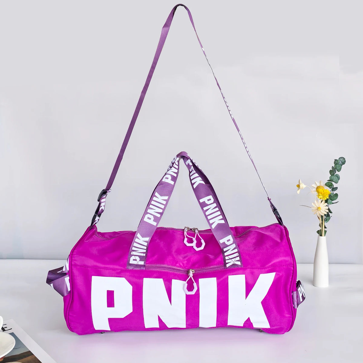 A bright pink Nike backpack with purple straps is displayed against a white background.