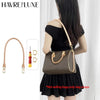 A woman is holding a brown leather shoulder bag with a gold strap, demonstrating the genuine Vachetta leather bag strap.
