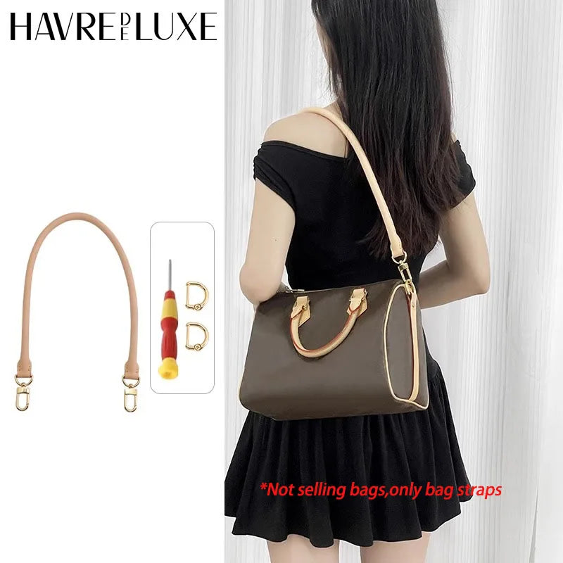 A woman is holding a brown leather shoulder bag with a gold strap, demonstrating the genuine Vachetta leather bag strap.