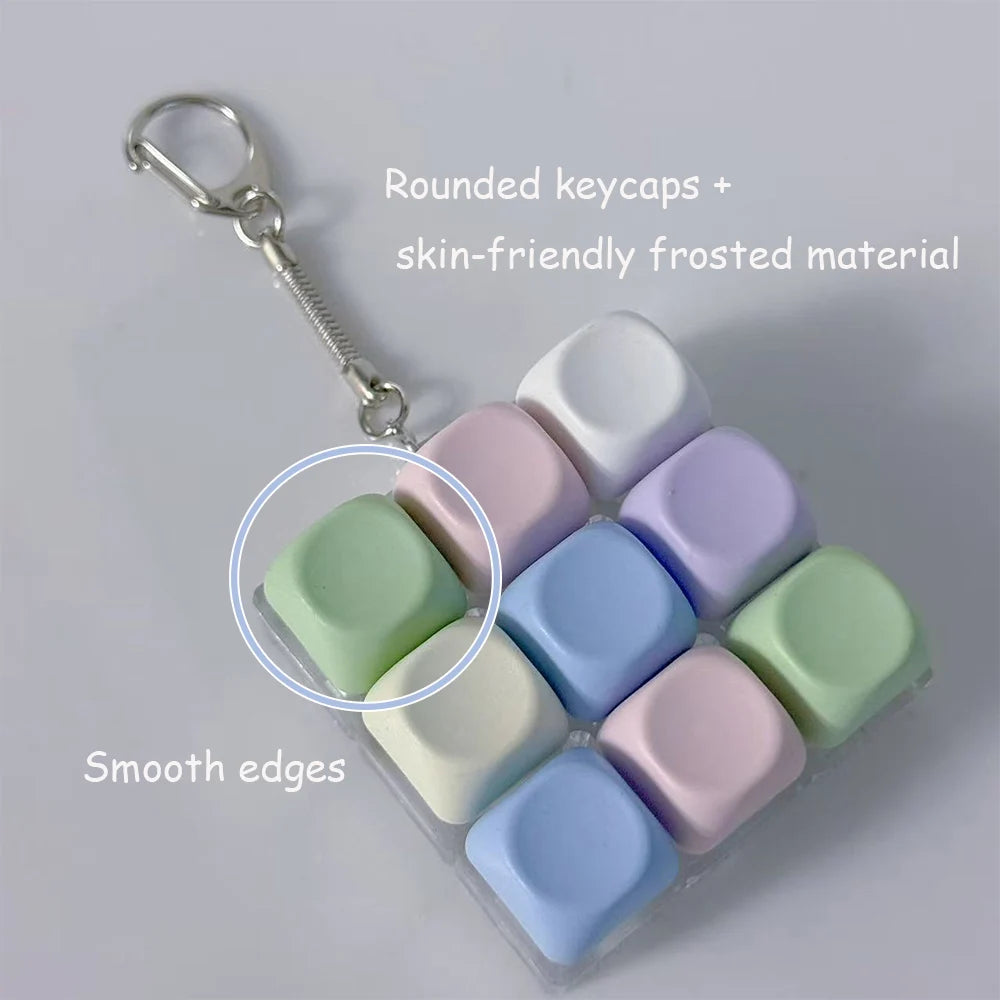 Ein Set von neun abgerundeten, skinfreundlichen, verfrosten Keycaps in verschiedenen Pastellfarben, arrangiert in einer klare