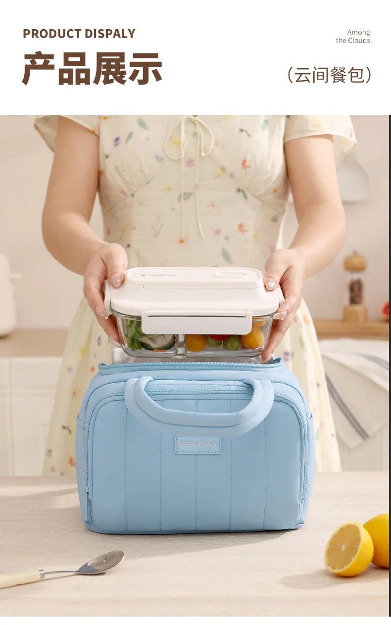 Una persona sostiene una bolsa de almuerzo acolchada azul aislada con un contenedor transparente, mostrando el producto.