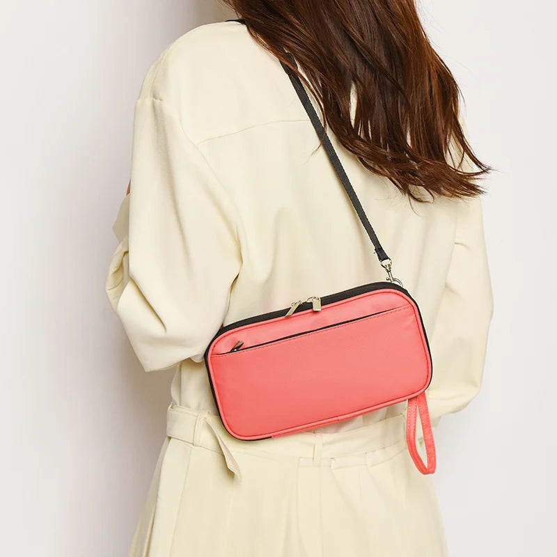 A woman holds a pink passport organizer pouch against a cream-colored jacket.