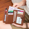 A brown leather clutch wallet with RFID blocking features is shown being held by a woman.