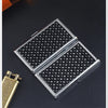 A silver metal cigarette case holder with a diamond pattern is shown on a dark surface.