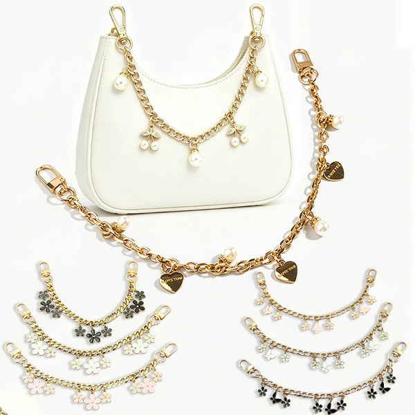 A gold chain necklace with pearl and flower charms displayed next to a white crossbody purse.