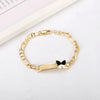 A gold-colored chain bracelet with a black butterfly charm on a white background.